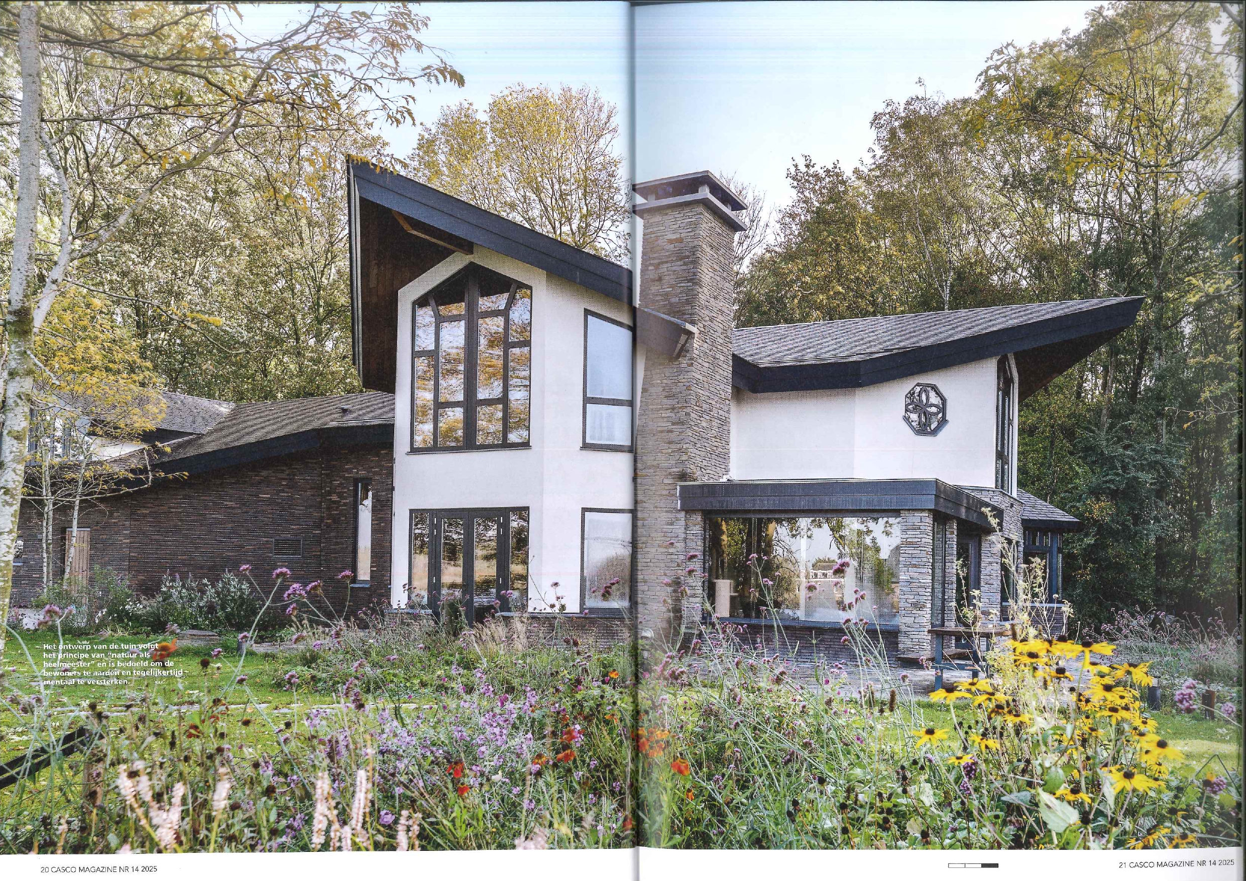 ORIO – Casco Magazine – Casa Energetica-7 Zijaanzicht van Animus Fluens met bloeiende ecologische tuin en asymmetrisch dak in bosrijke omgeving